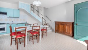 Una cocina con comedor, una escalera y un armario de madera.