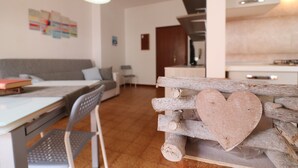 Een moderne leefruimte met een houten bank, een tafel en een sofa.