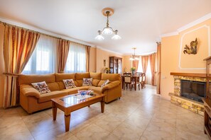 Una sala de estar con sofá, mesa de centro, chimenea y comedor.