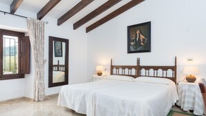 A bedroom with a large bed, two bedside tables with lamps, a mirror, and a painting on the wall. - Villa "Son Perxa" with Pool and Garden (Petra)