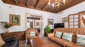 A living room with leather sofas, a wooden coffee table, a TV, and framed artwork on the walls. - Villa "Son Perxa" with Pool and Garden (Petra)