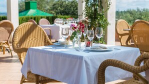 An outdoor dining area with wicker chairs and a table set for a meal, surrounded by greenery and a clear sky. - Villa "Son Perxa" with Pool and Garden (Petra)