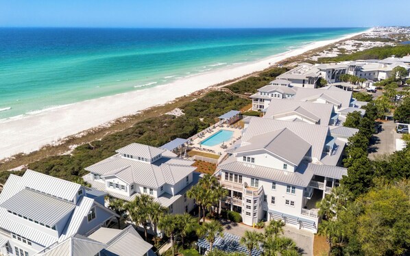 A coastal residential area with houses, a beach, and a swimming pool.