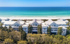A beachfront hotel with multiple buildings, balconies, and a view of the ocean.