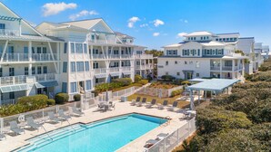 Um resort com piscina, várias varandas e um jardim bem cuidado.