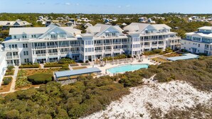 Een groot resort met meerdere gebouwen, een zwembad en een strand.