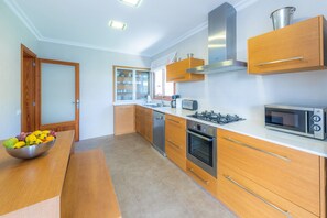 A modern kitchen with wooden cabinets, a gas stove, a microwave, and a dishwasher.