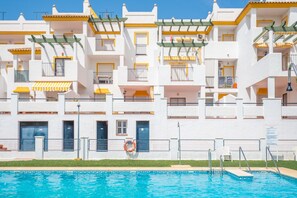 Un hôtel à plusieurs étages doté de balcons, d’une piscine et d’une bouée de sauvetage.