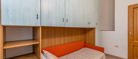 Un dormitorio con cama, armario y puerta.