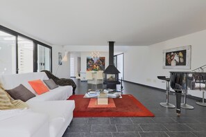 Ein modernes Wohnzimmer mit einem weißen Sofa, einem roten Teppich und einem Kamin.