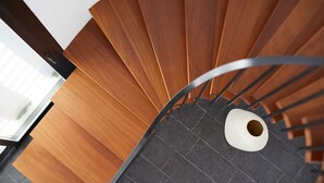 Un escalier en colimaçon avec des marches en bois et une rampe métallique.
