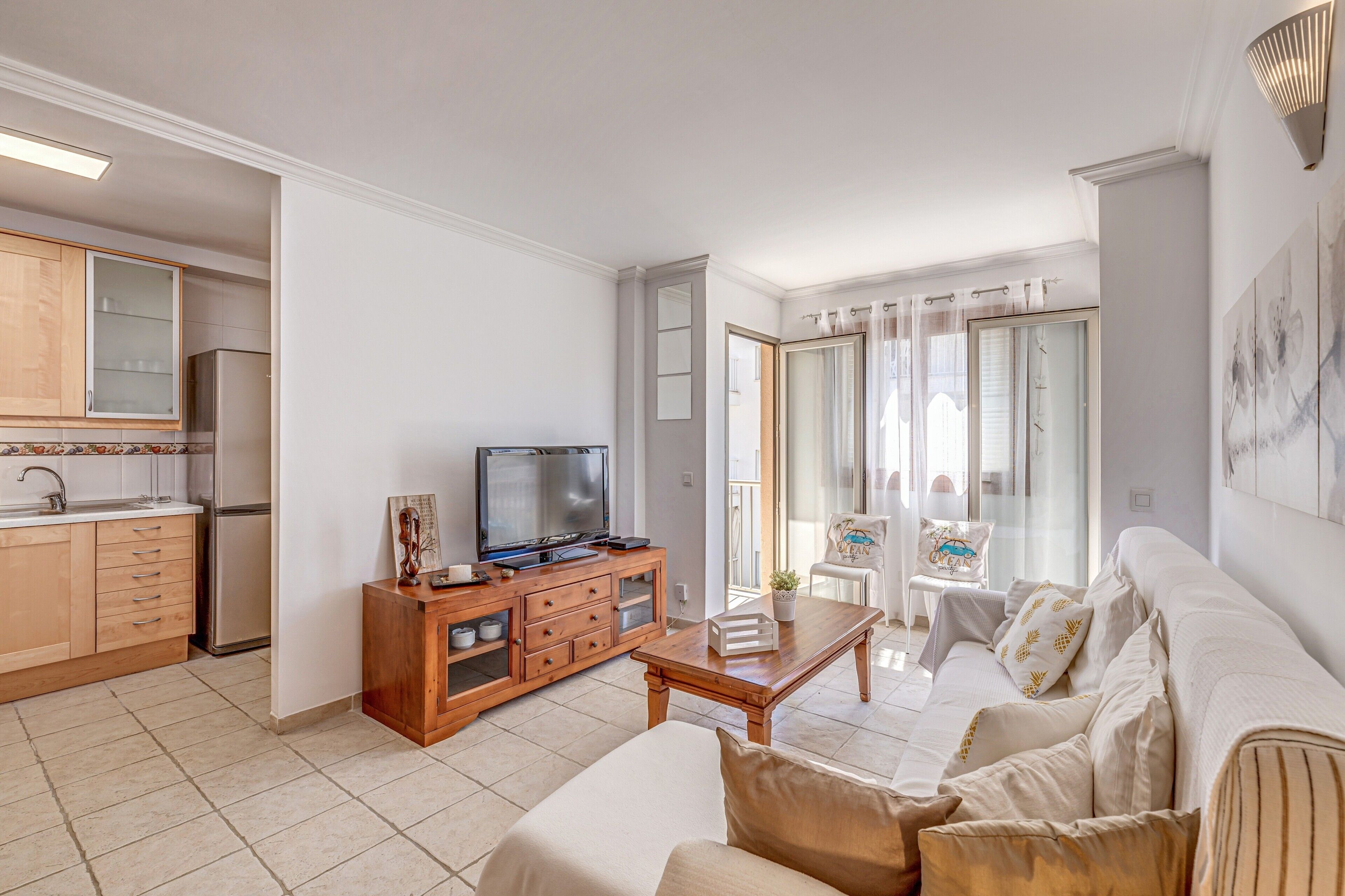 A living room with a sofa, a coffee table, a TV, and a wooden cabinet.