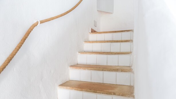 Eine Treppe mit Holzbodenstufen und einem Seilgeländer.