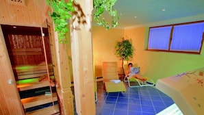 A sauna room with wooden benches, a bench with a towel, a small table, and a plant. - Apartment “Petrushof Ferienwohnung Taubensee” with Mountain View, Wi-Fi, Balcony (Oberwössen)