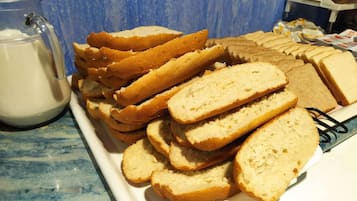 A plate of sliced bread and a jug of milk on a table.