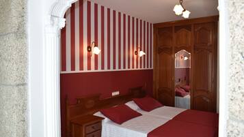 Un dormitorio con una cama de madera, dos mesitas de noche y un espejo.