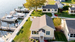 A residential area with houses, a dock with boats, and a well-maintained lawn. - Old Pike Cottages (Saugatuck)