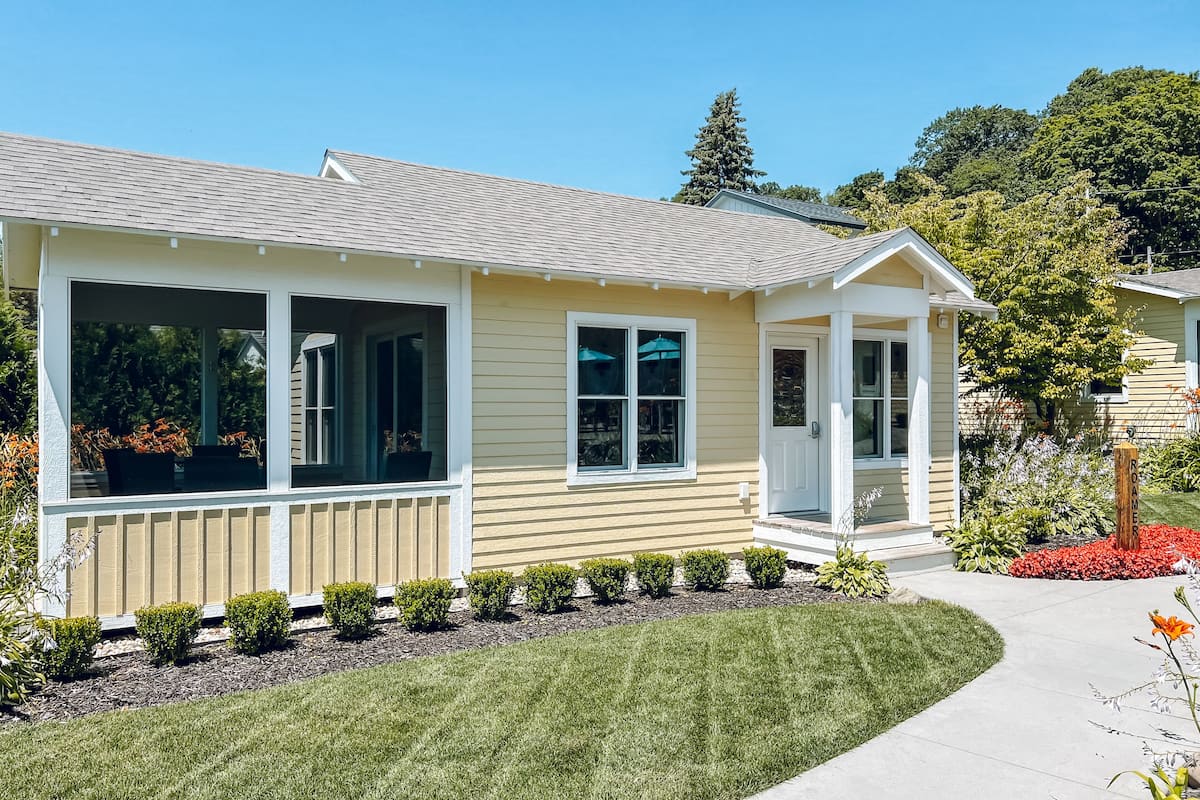 A single-story house with a covered porch, a front door, and a small attached garage.