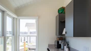 A modern kitchen with a large window, a built-in oven, and a sink.