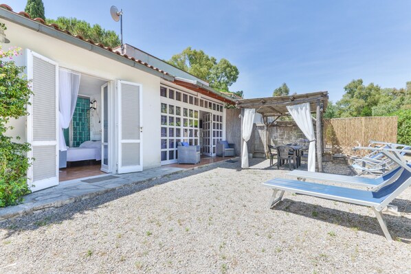 Una casa con un patio abierto, un área de estar techada y una piscina.
