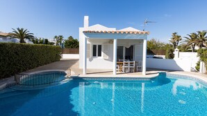 A swimming pool with a white building adjacent to it. - Air-Conditioned Holiday Home on the Beach with Pool, Terraces & Wi-Fi (Ciutadella de Menorca)