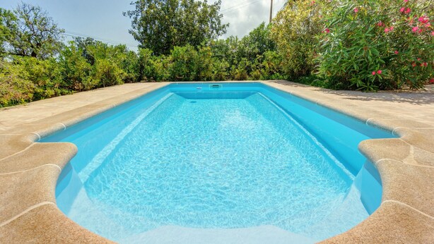 A rectangular swimming pool with clear blue water, surrounded by a stone deck. - Country house "Sa Barraca d'en Camine" with pool in the nature (portopetro)