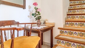 A wooden chair, a small table with a vase of flowers, and a staircase with patterned tiles. - Country house "Sa Barraca d'en Camine" with pool in the nature (portopetro)