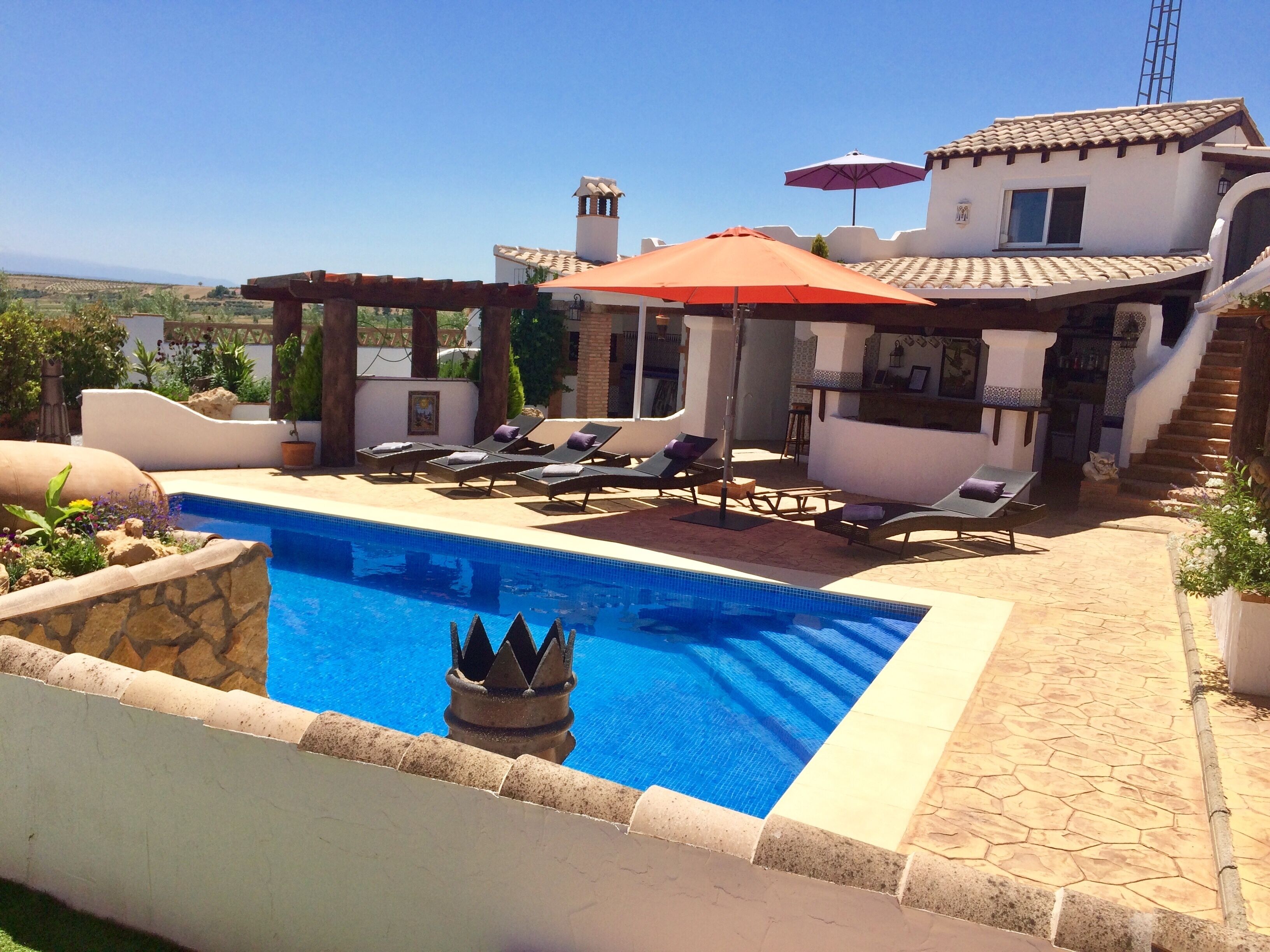 حمّام سباحة خارجي، مظلات على حمّام السباحة، مقاعد للتشمس