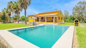A yellow house with a swimming pool, surrounded by palm trees and a well-maintained lawn. - Peaceful location with pool - Villa Can Jaume (Pollença)