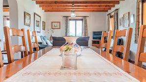 A dining table with chairs, a vase, and a candle. - Peaceful location with pool - Villa Can Jaume (Pollença)