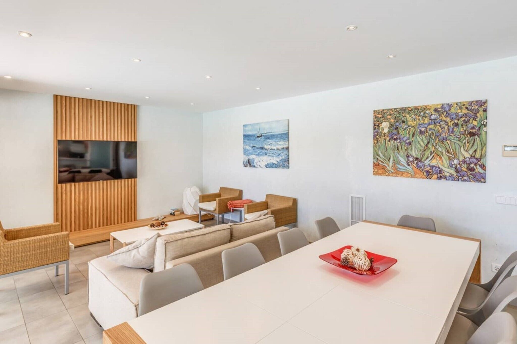 Un intérieur moderne comprenant un coin repas, des sièges et des œuvres d’art accrochées aux murs.