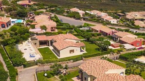 Un quartier résidentiel avec des maisons, une piscine et une vue sur la mer.