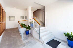 A staircase with white steps and wooden handrails, leading to an upper floor.