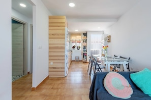 Une cuisine moderne avec un coin repas, un lambris en bois et une petite table avec des chaises.