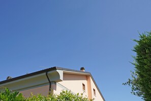 Un bâtiment doté d’un toit plat, d’une cheminée et d’une petite fenêtre.
