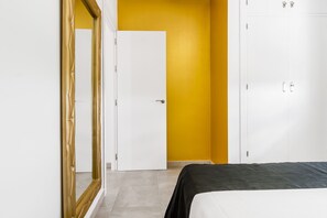 Een slaapkamer met een bed, een kledingkast en een deur.
