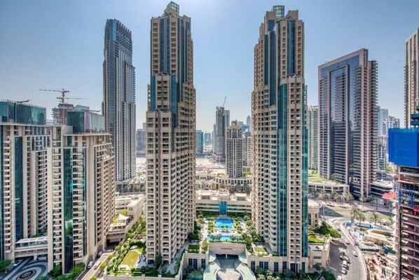 Un ensemble immobilier résidentiel de grande hauteur, composé de plusieurs tours, d’un espace paysager central et d’une piscine.