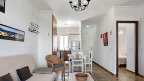 Un soggiorno con divano, poltrone, tavolo e lampadario.