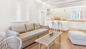 Ein modernes Wohnzimmer mit einer Couch, einem Couchtisch und zwei Korbstühlen.