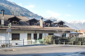 A building with multiple rooms, a sign indicating a restaurant, and a view of snow-capped mountains.