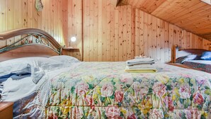 A wooden-paneled room with a bed, a nightstand, and a wall-mounted light fixture. - Apartment “Mansarda tra le Dolomiti di Brenta" with Mountain View & Balcony (Bocenago)