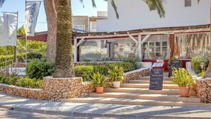 Een restaurant met terras, stenen muren en plantenpotten.