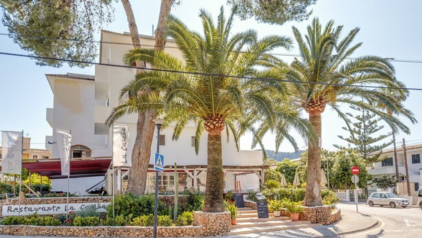Een gebouw met een bord waarop 'Restaurante La Cala' staat.