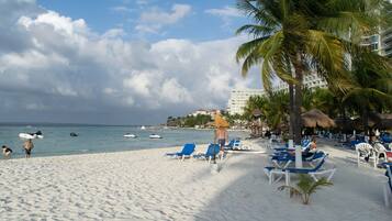 On the beach, white sand, sun-loungers, beach towels