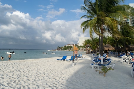On the beach, white sand, sun loungers, beach towels