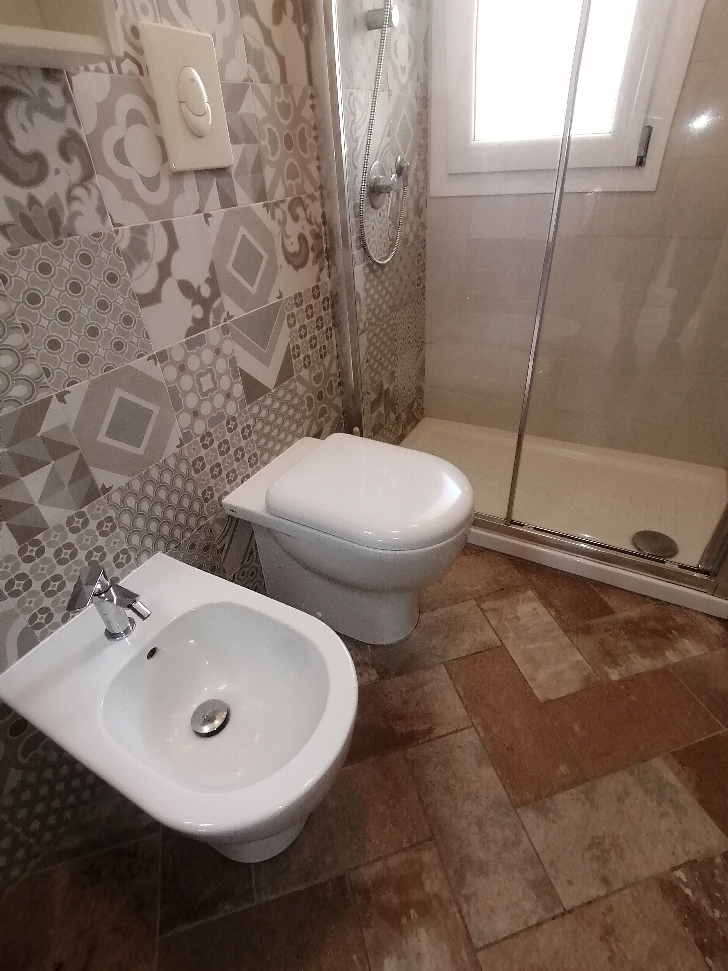 Ein Badezimmer mit Dusche, Toilette und Bidet.