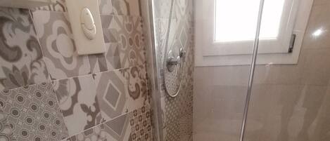 Ein Badezimmer mit Dusche, Toilette und Bidet.