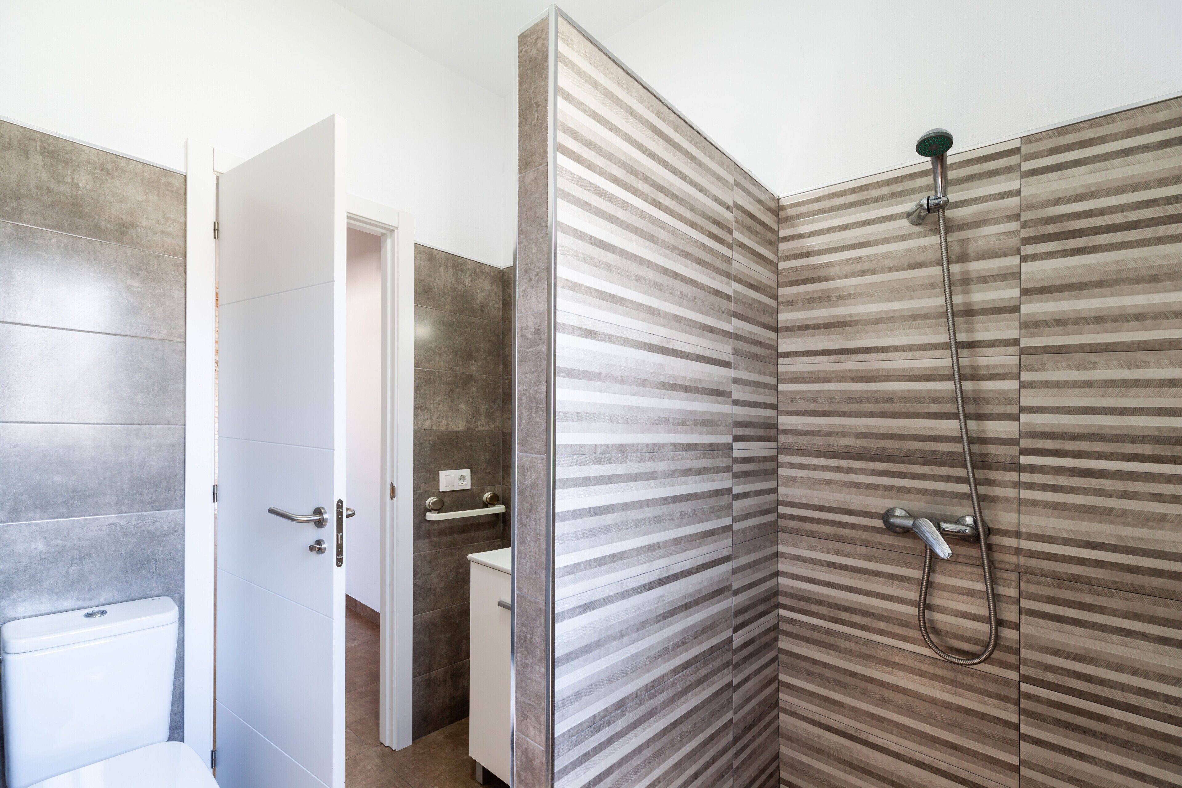 A bathroom with a shower, toilet, and sink.