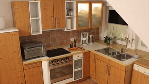 Une cuisine avec des meubles de rangement en bois, un four encastré, une machine à café et un évier.