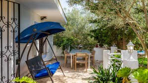 A patio with a swing chair, a table, and chairs. - In the country with pool - Villa Can Garba (Felanitx)